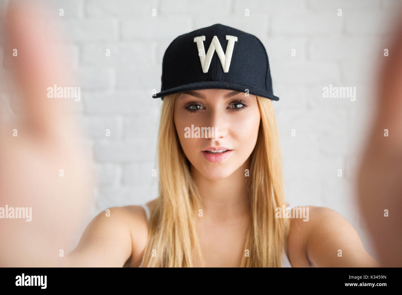 A photo of young, beautiful woman wearing black cap. She's setting up