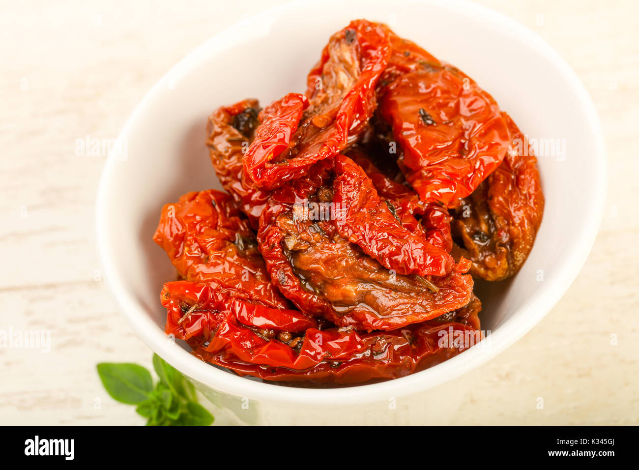 Dried tomato in olive oil with basil leaves Stock Photo Alamy