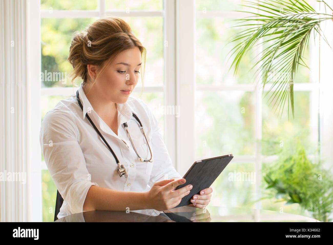 Young medical doctor woman seating at the table with sthetoscope and ...