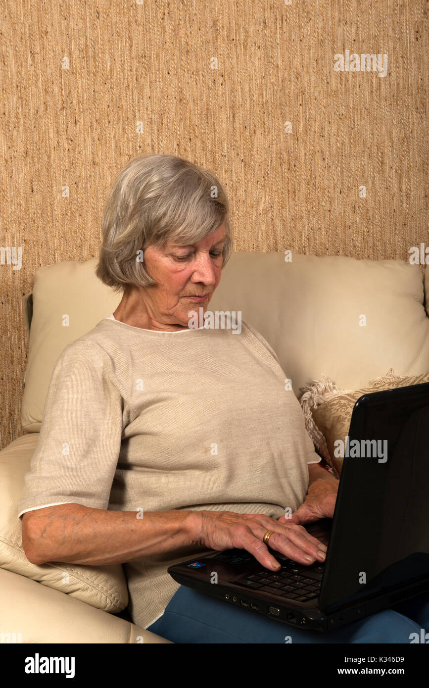 Elderly woman using a laptop computer for online shopping Stock Photo