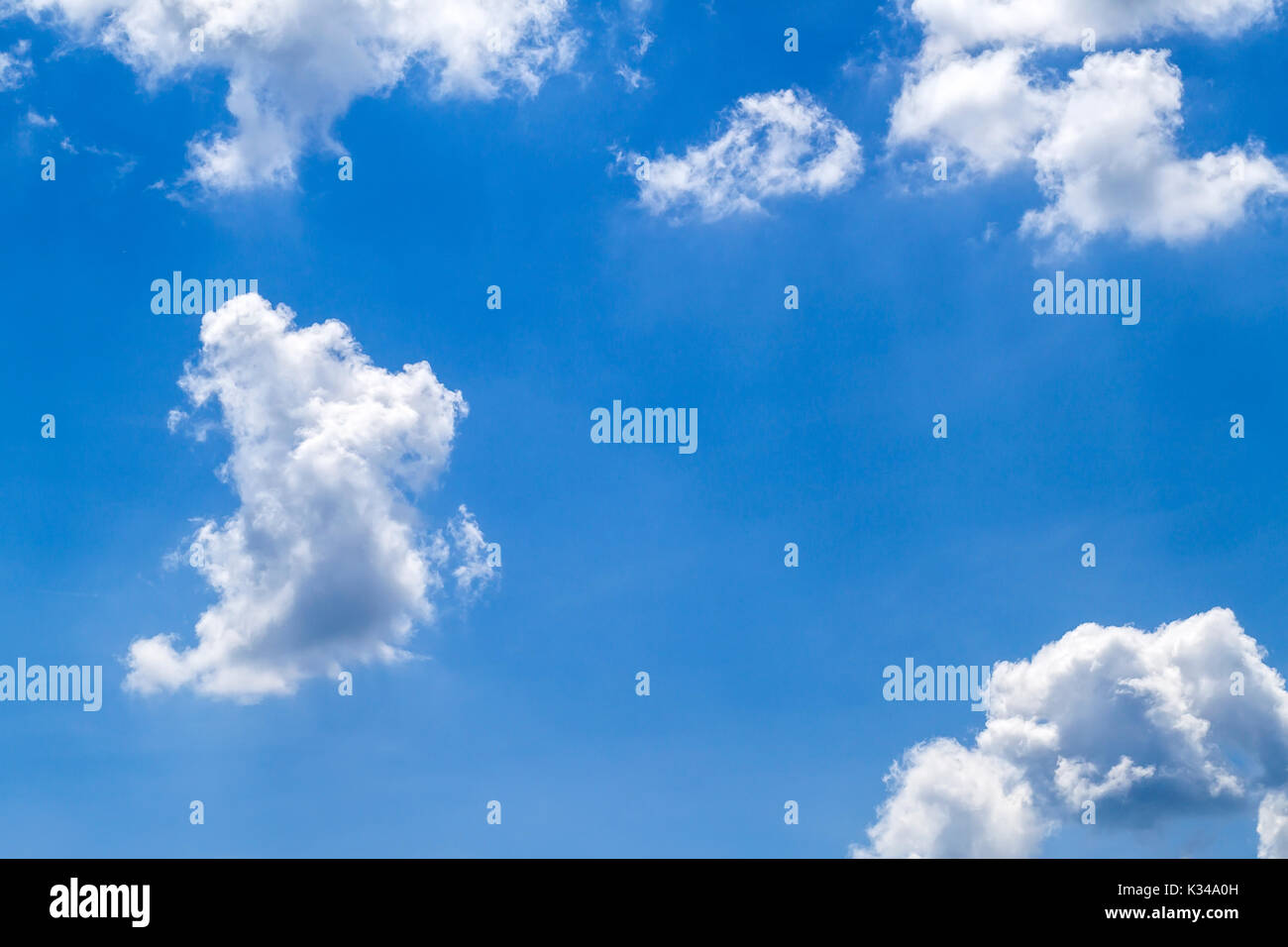 Blue vibrant sky with puffy white clouds Stock Photo - Alamy