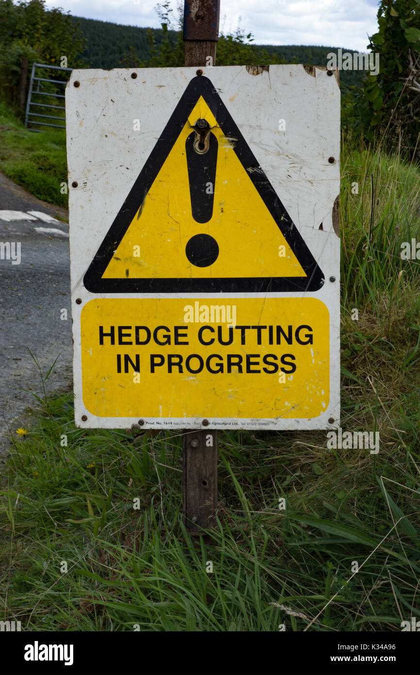 Hedge cutting in progress sign. Powys. Wales Stock Photo