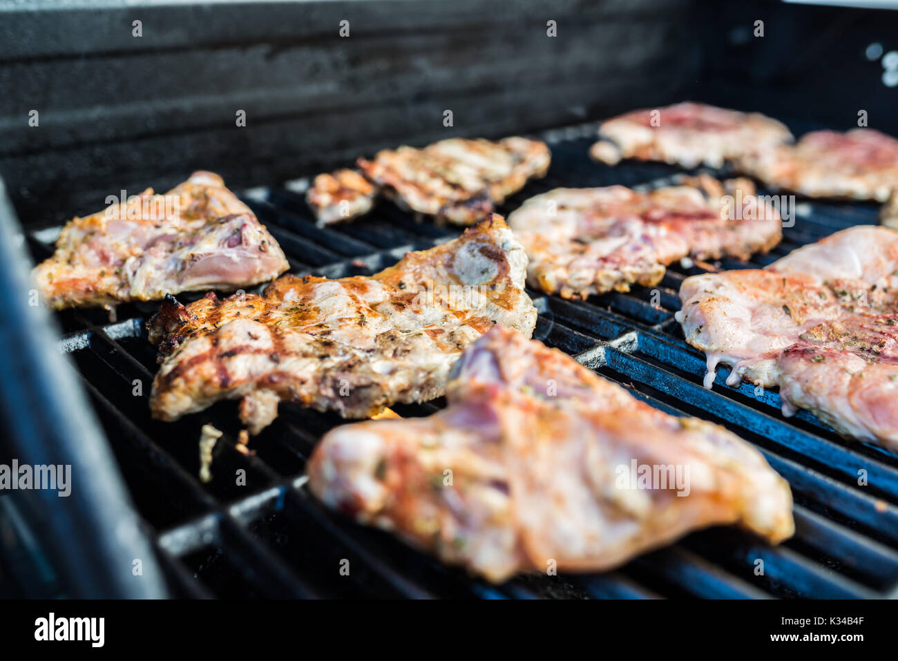 Delicious pork steaks with seasoning on the grill Stock Photo