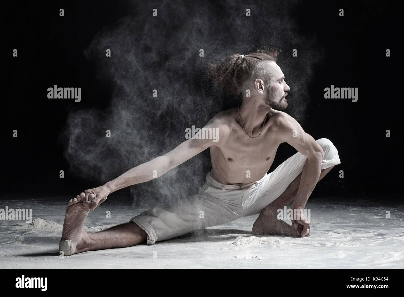 Flexible yoga man doung wide side lunge or utthita namaskarasana. Stock Photo