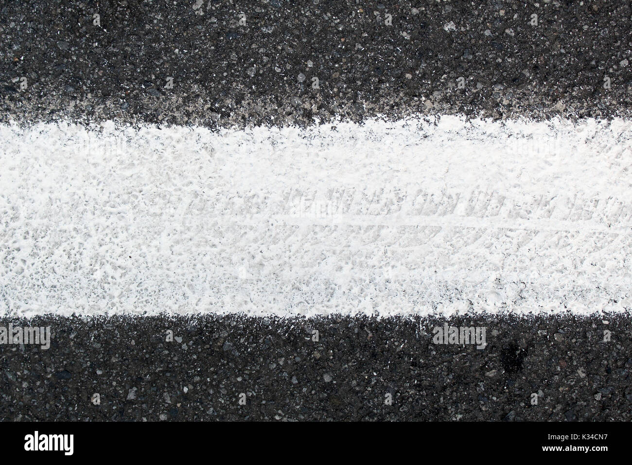 Closeup of road surface with white paint line, horizontal center position. Stock Photo