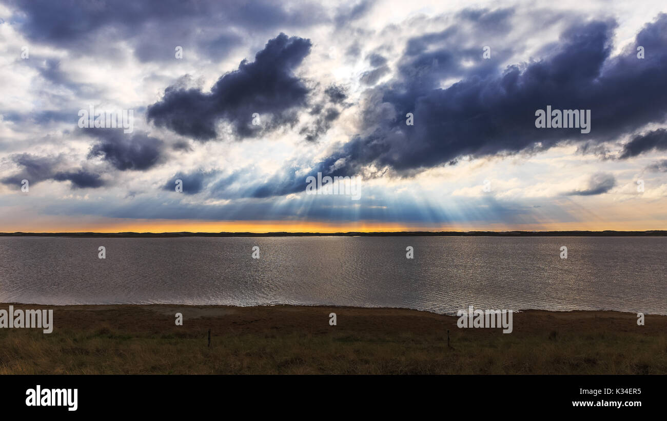 The sun shines through the clouds near Agger Tange Stock Photo