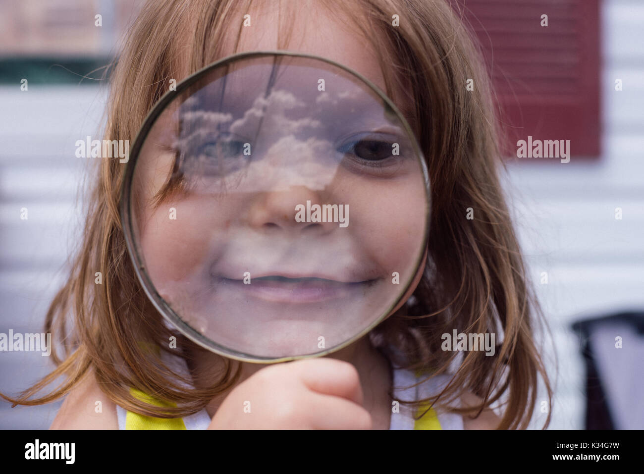 A young girl looks through a circular magnifying glass Stock Photo Alamy