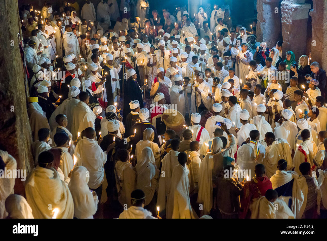 Priests chanting prayers by candlelight in the courtyard of Bet Medhane Alem church, during the prayers on Ethiopian Orthodox Easter Saturday, Lalibela, Ethiopia Stock Photo