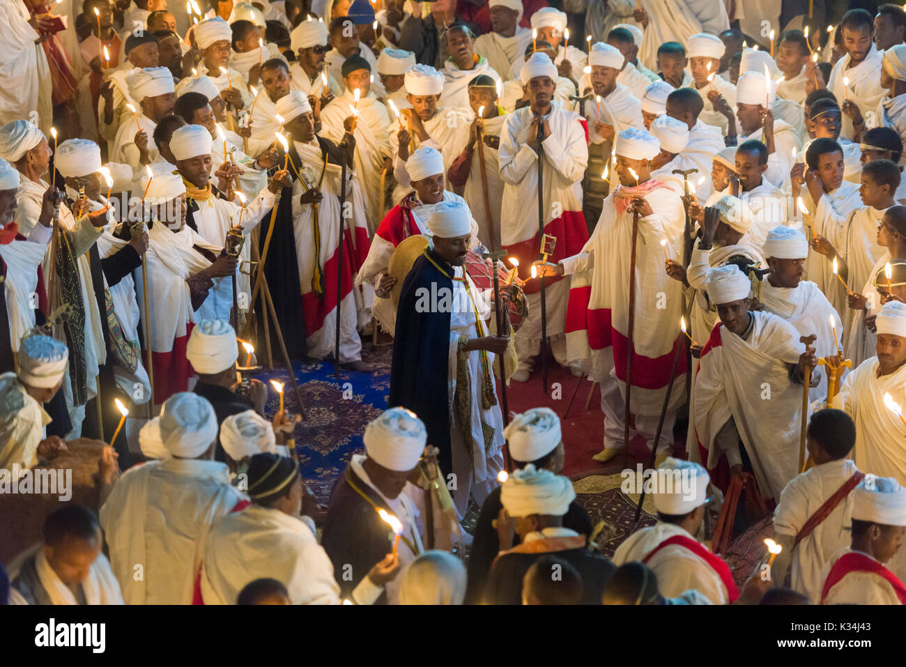 Priests chanting prayers by candlelight in the courtyard of Bet Medhane Alem church, during the prayers on Ethiopian Orthodox Easter Saturday, Lalibela, Ethiopia Stock Photo