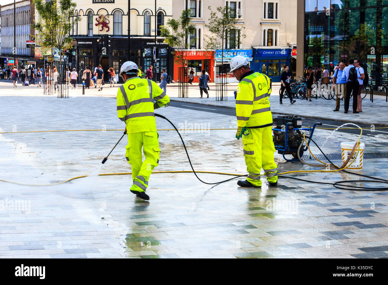 Street cleaners with pressure hoses in 'Navigator Square', removing
