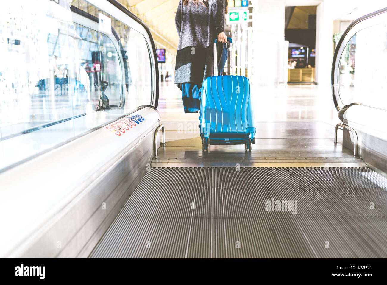 Woman passing from a Moving Walkway to a Floor Stock Photo