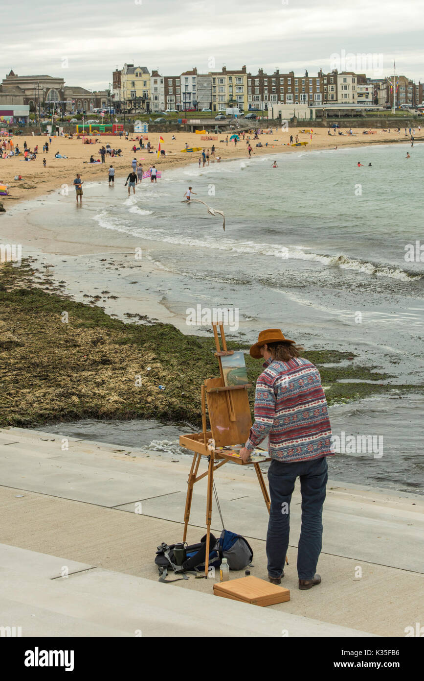 an easel with a picture stands on the seashore without people on a sunny  day Stock Photo - Alamy