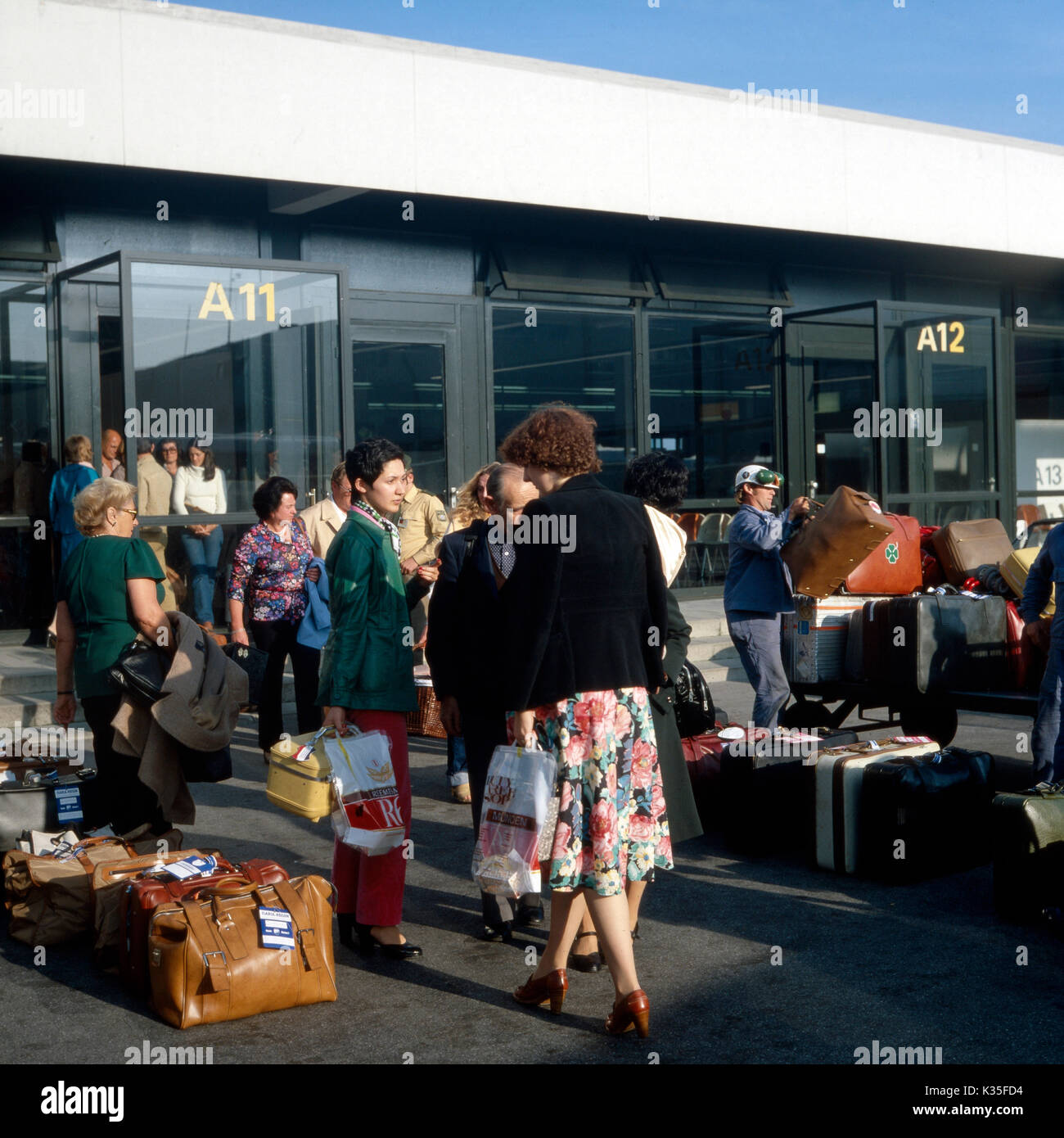 Passagiere vorm Abflug am Flughafen München, 1980er. Passengers before departure at Munich Airport, 1980s. Stock Photo