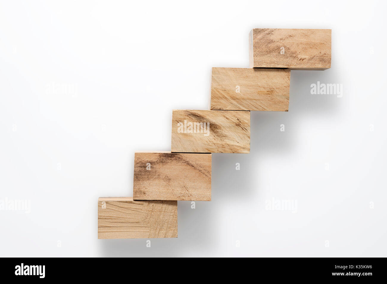simple wooden blocks ladder with shadow isolated on white Stock Photo