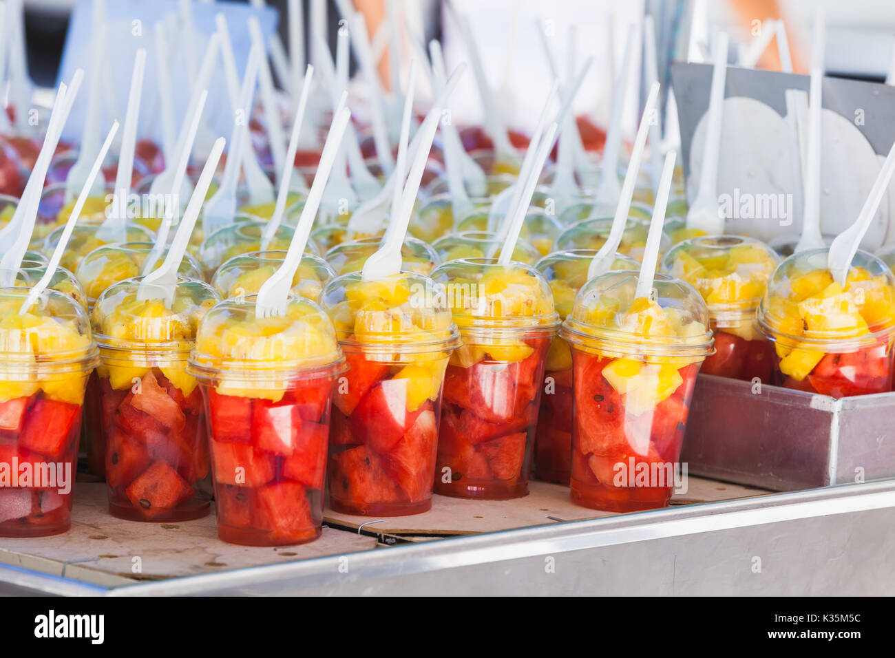 Fresh fruits sorted in plastic cups with forks. Street dessert shop in Lisbon, Portugal. Close-up photo with selective focus Stock Photo