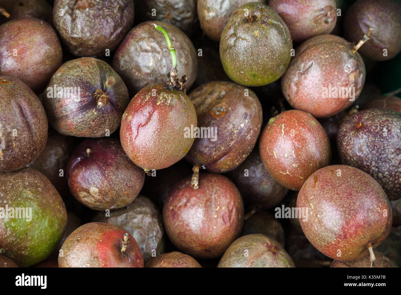 Passion fruits lay on the counter of street food market on Madeira island, Portugal. Close-up photo with selective focus Stock Photo