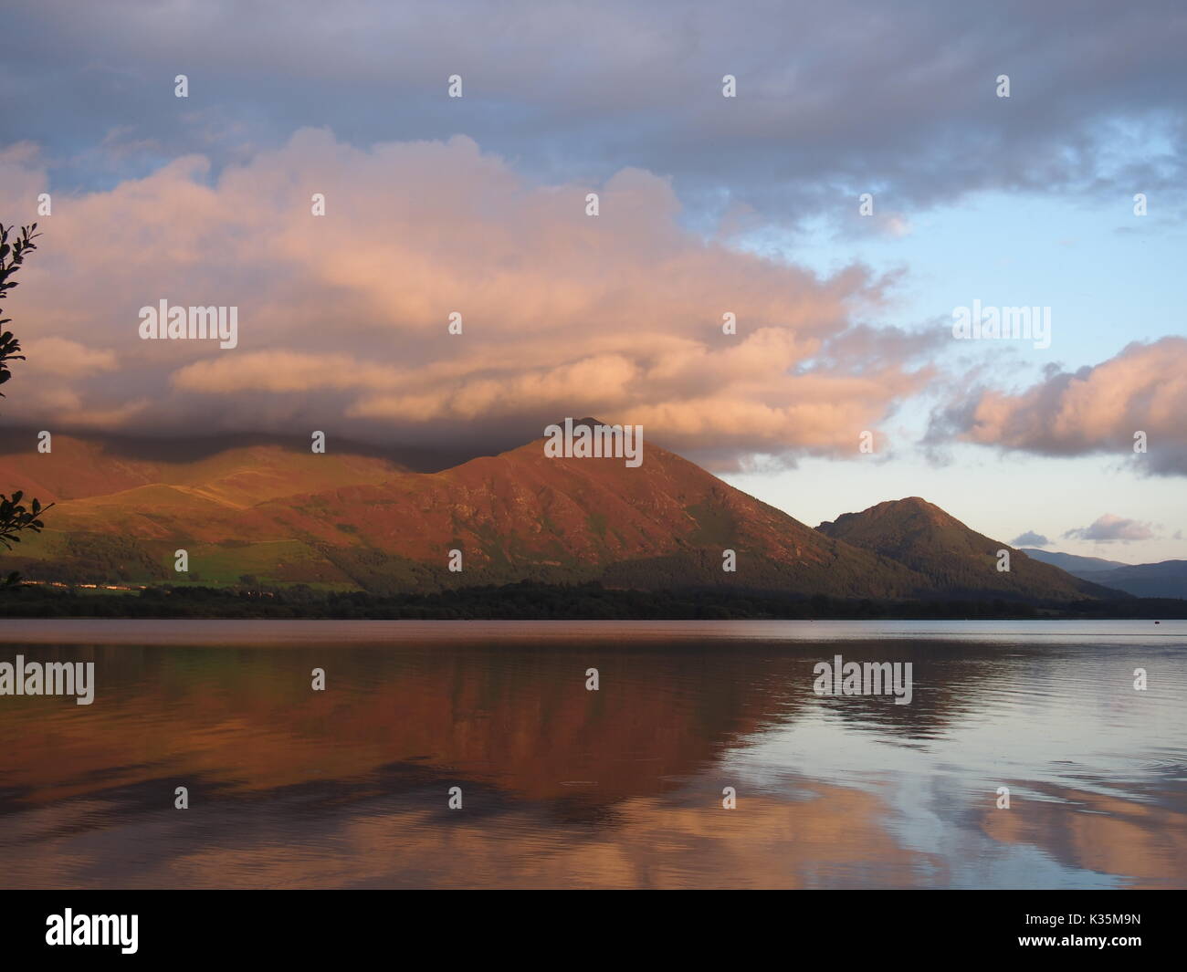 Sunlit Clouds and Lakeland Fells reflected in Bassenthwaite Lake, Cumbria, United Kingdom Stock Photo