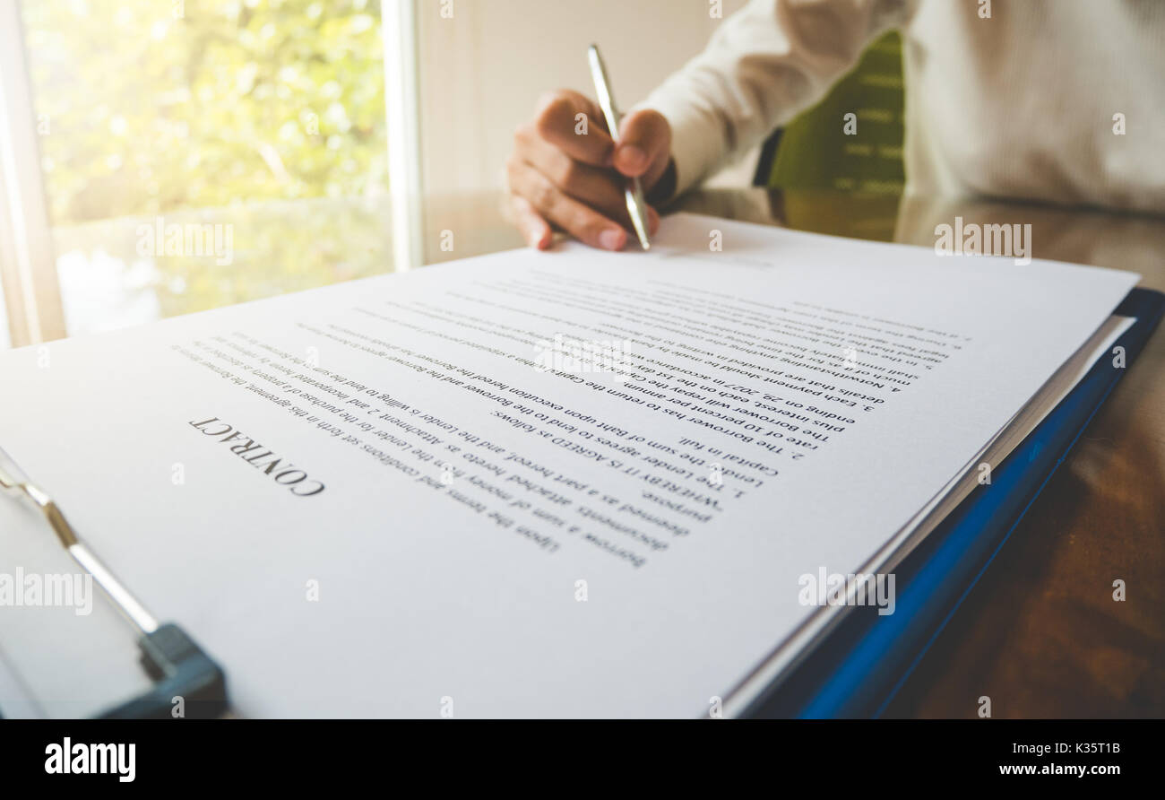 Close up hand hold pen for signature on contract document in business ...