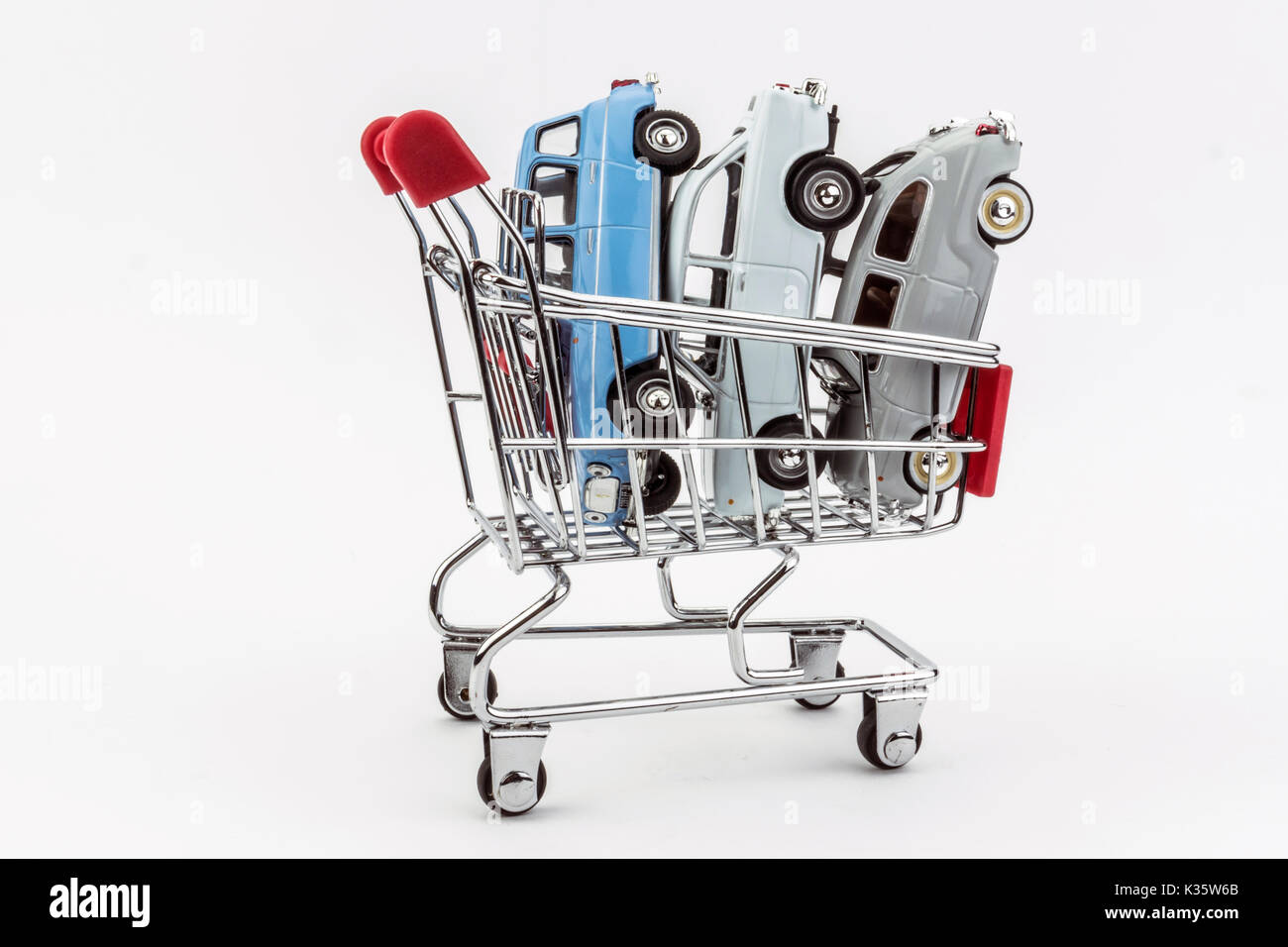 Traditional shopping cart full of miniature cars, business concept