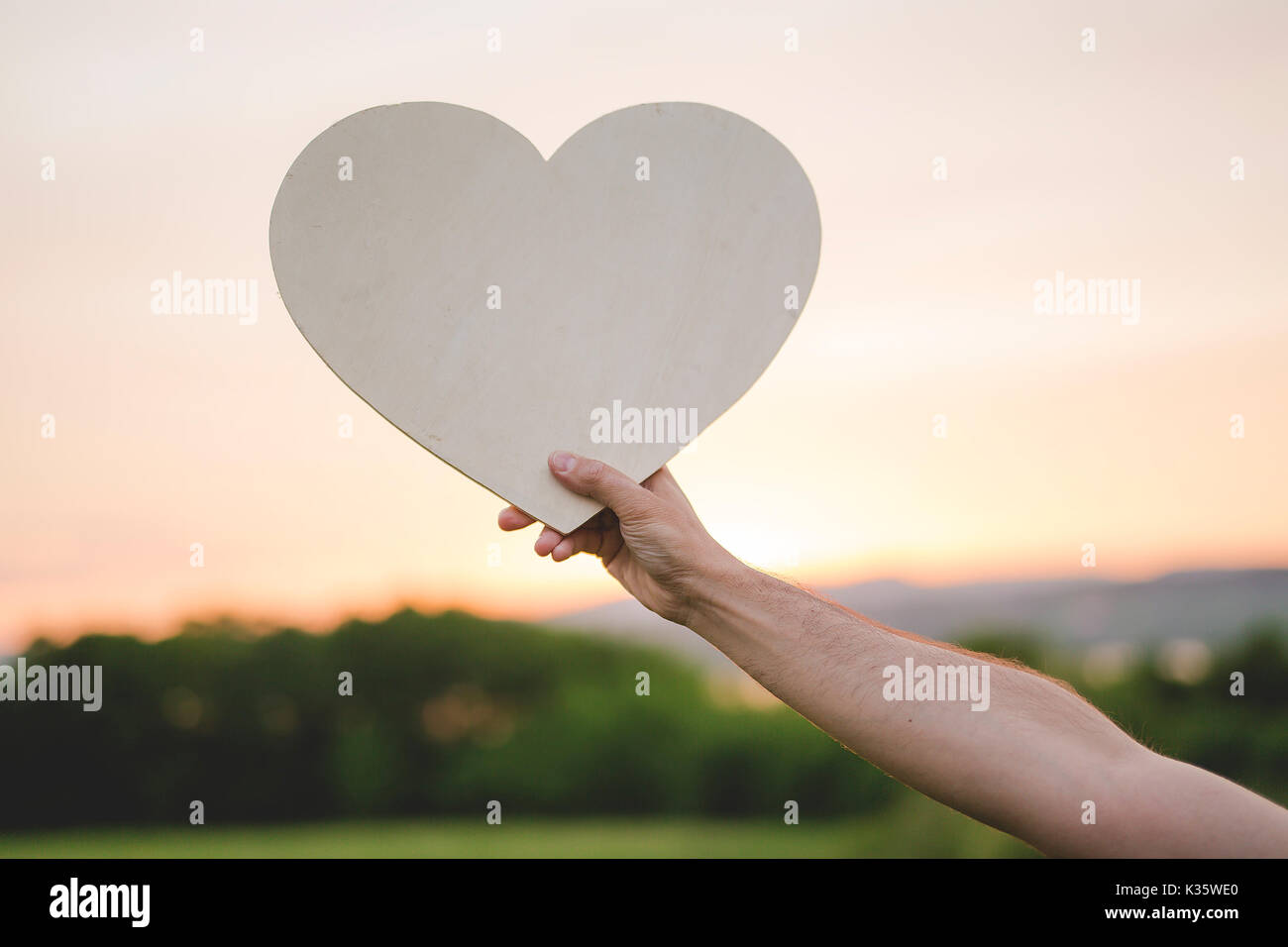 hand holding heart shape at the sky sunset background Stock Photo - Alamy