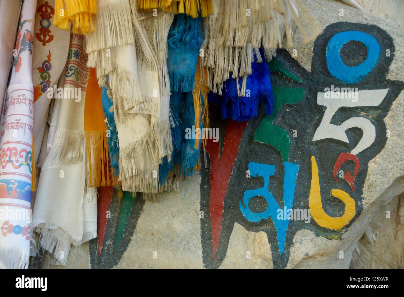 Khata, the traditional scarves, and Tibetan script on a wall in Lo Manthang, Upper Mustang, Nepal Stock Photo