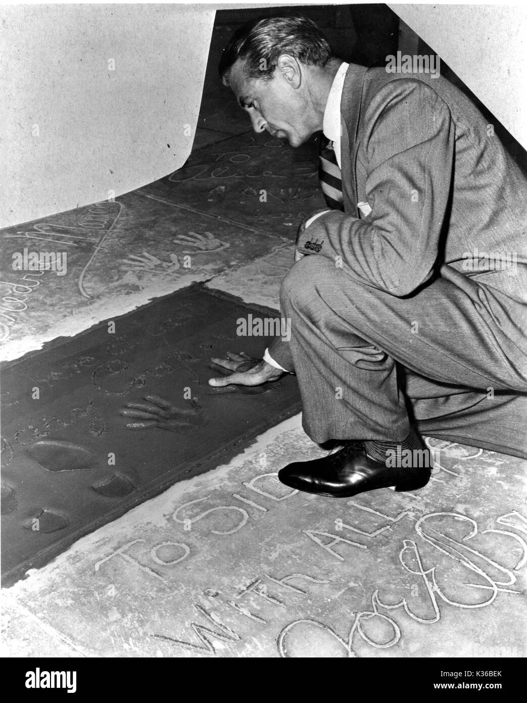 Gary Cooper making handprints in wet cement outside Sid Grauman's Chinese Theatre in Hollywood Stock Photo