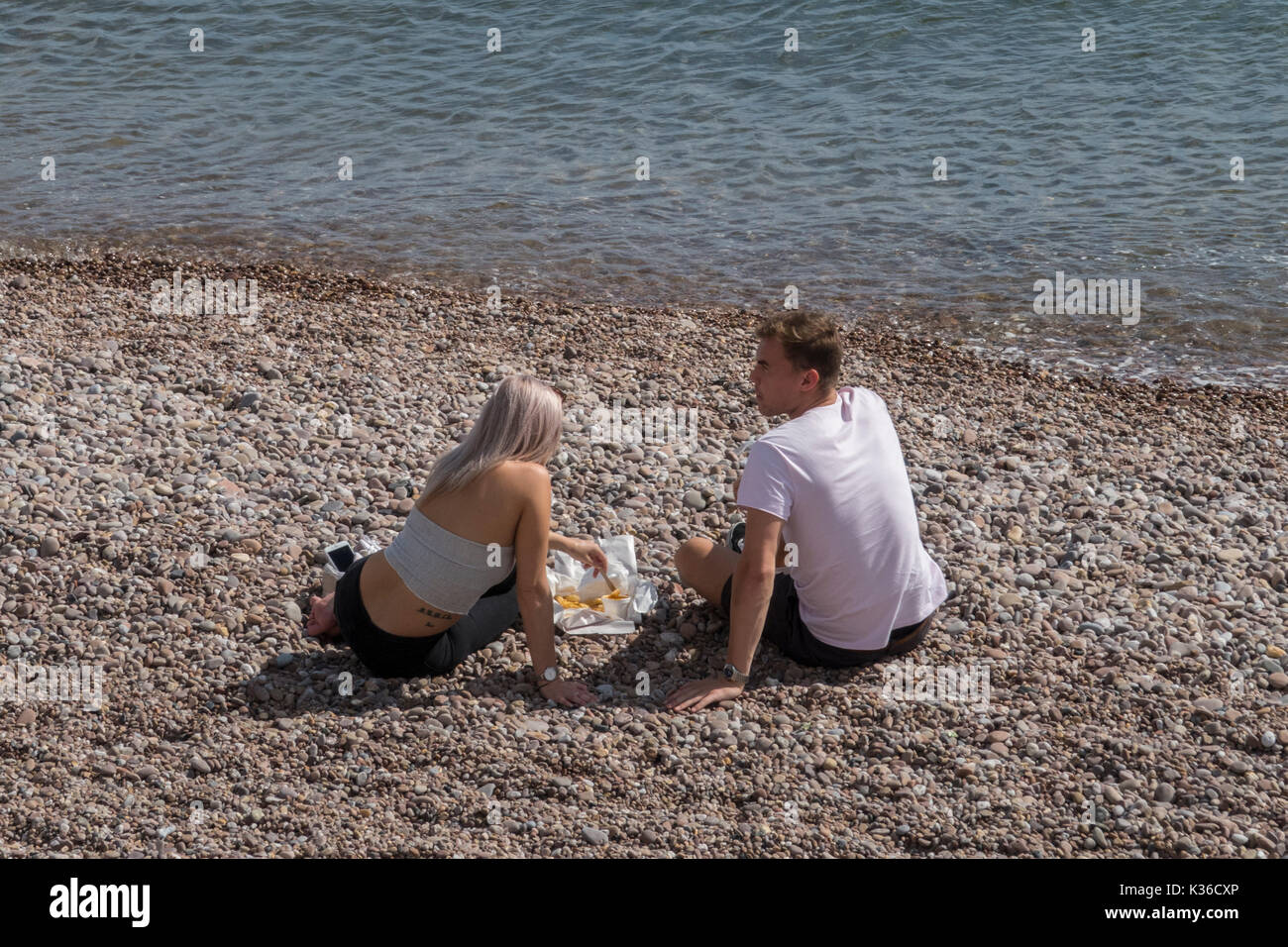 Sidmouth 1st Sept 17    Glorious weather on the Devon coast on the first day of autumn. A couple enjoy a traditional English meal on Sidmouth beach. Credit: Photo Central / Alamy Live News Stock Photo