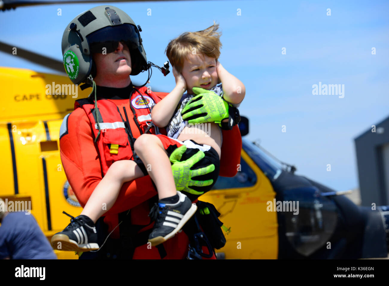 Houston, United States. 31st Aug, 2017. U.S. Coast Guard rescue swimmer Evan Gallant carries a boy away from an MH-60 Jayhawk helicopter following evacuation in the aftermath of Hurricane Harvey August 31, 2017 in Houston, Texas. Credit: Planetpix/Alamy Live News Stock Photo