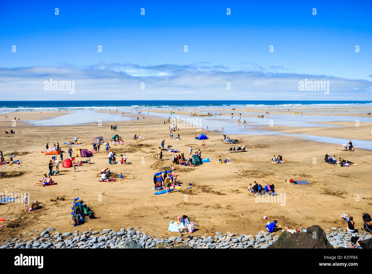 Holidaymakers head to the beach to cool off in the sea as temperatures rise, Westward Ho!, Devon, UK Stock Photo