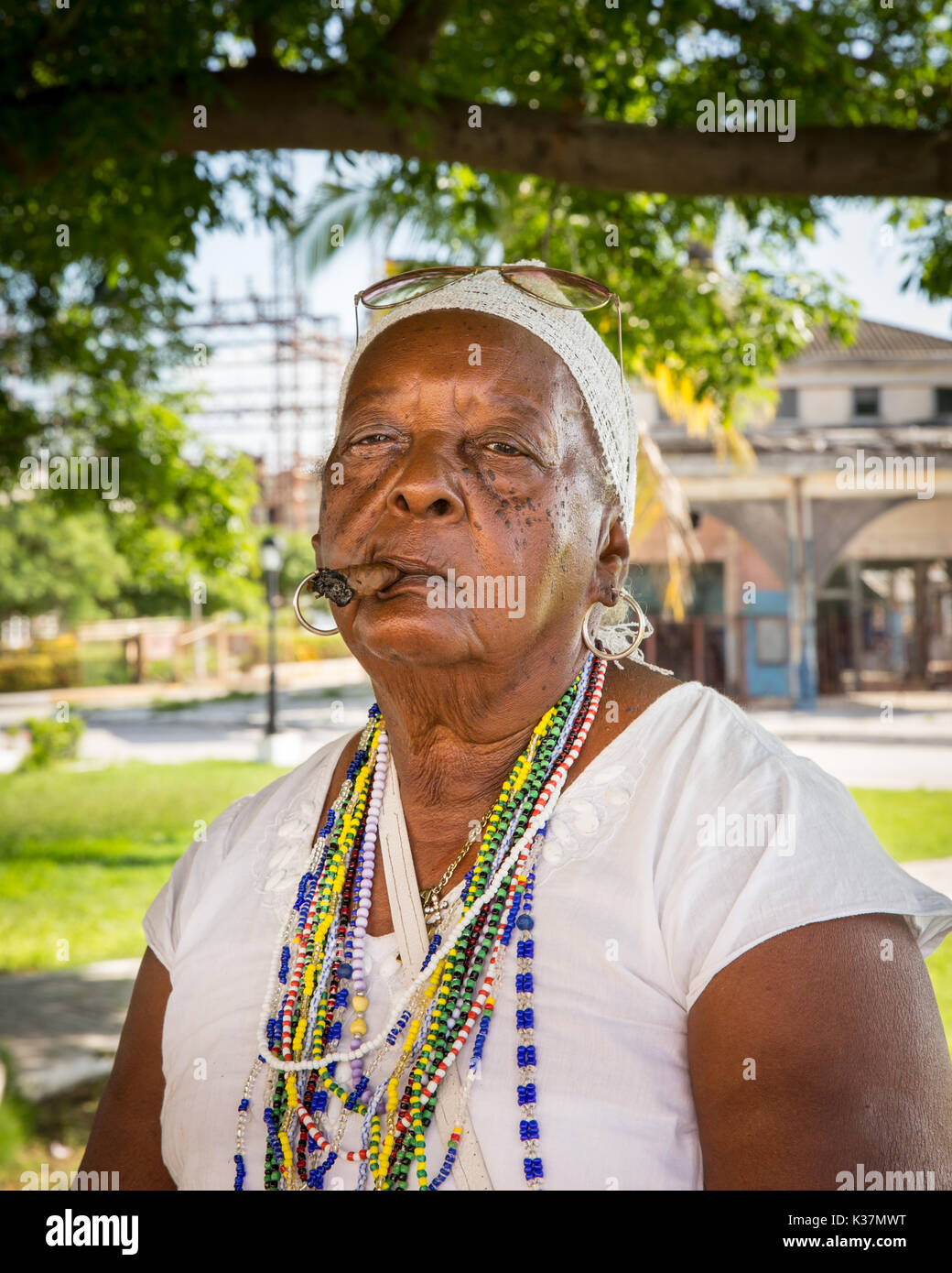 Santeria woman smoking cigar, Cuban woman following the Santeria religion in Regla, Cuba Stock Photo