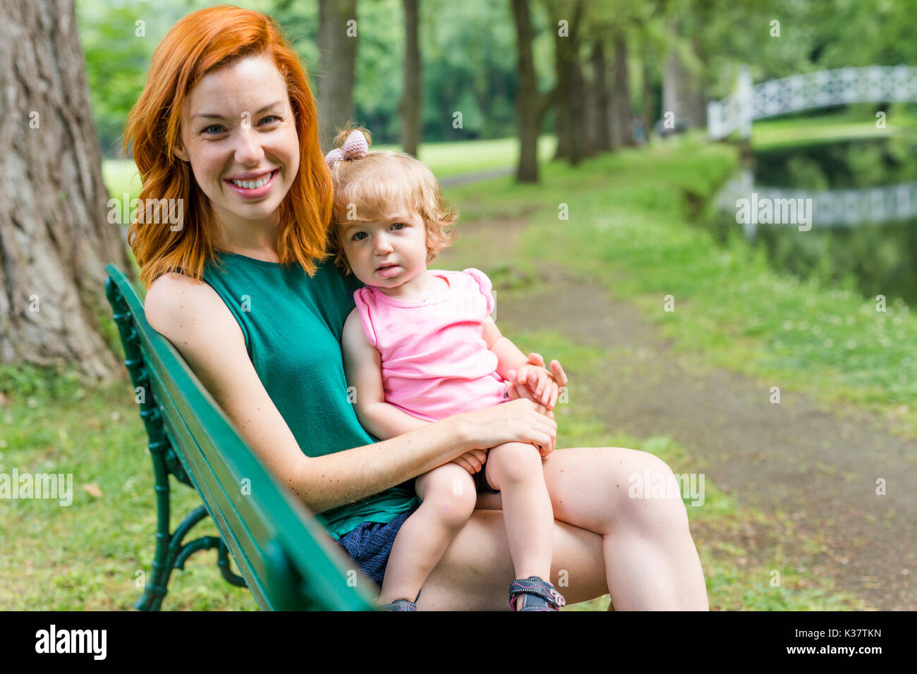 mother and her little daughter sitting on a park bench Stock Photo - Alamy