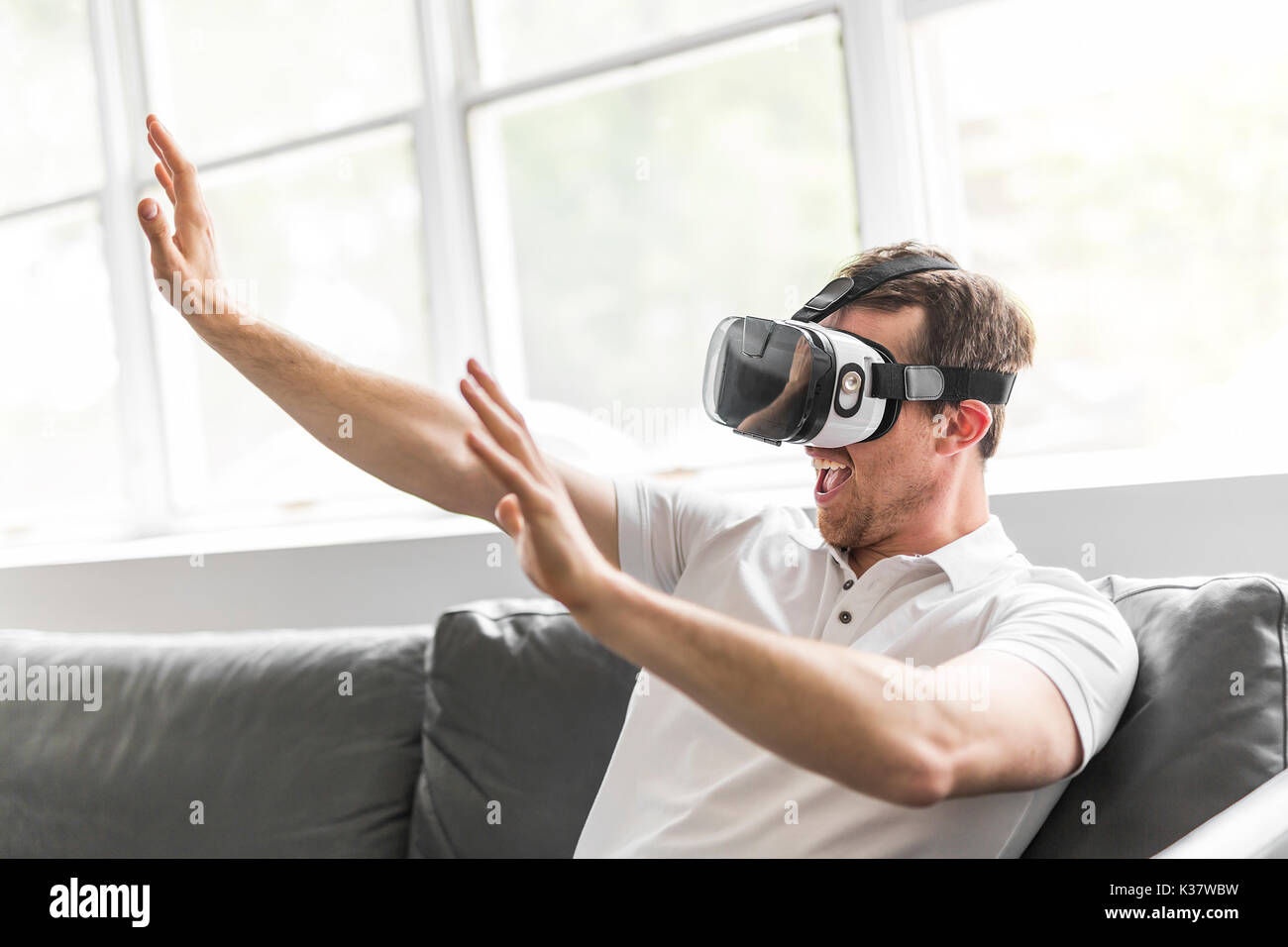 young man wearing virtual reality goggles in modern coworking studio ...