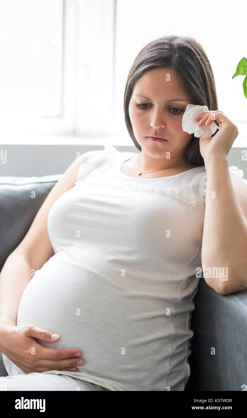 Sad pregnant woman lying on sofa at home Stock Photo Alamy