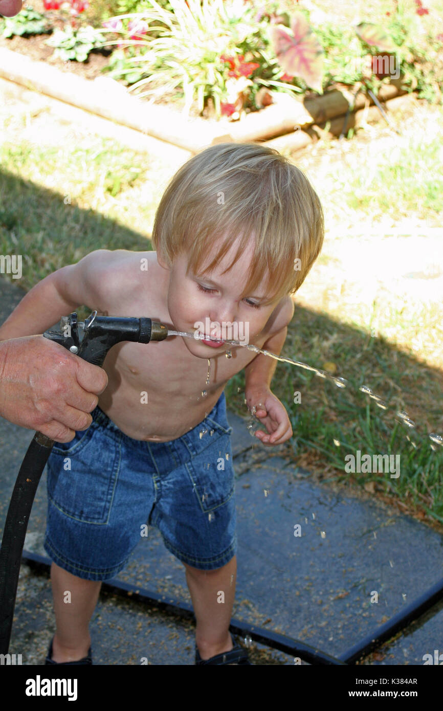 Boy drinking from water hose hires stock photography and images Alamy