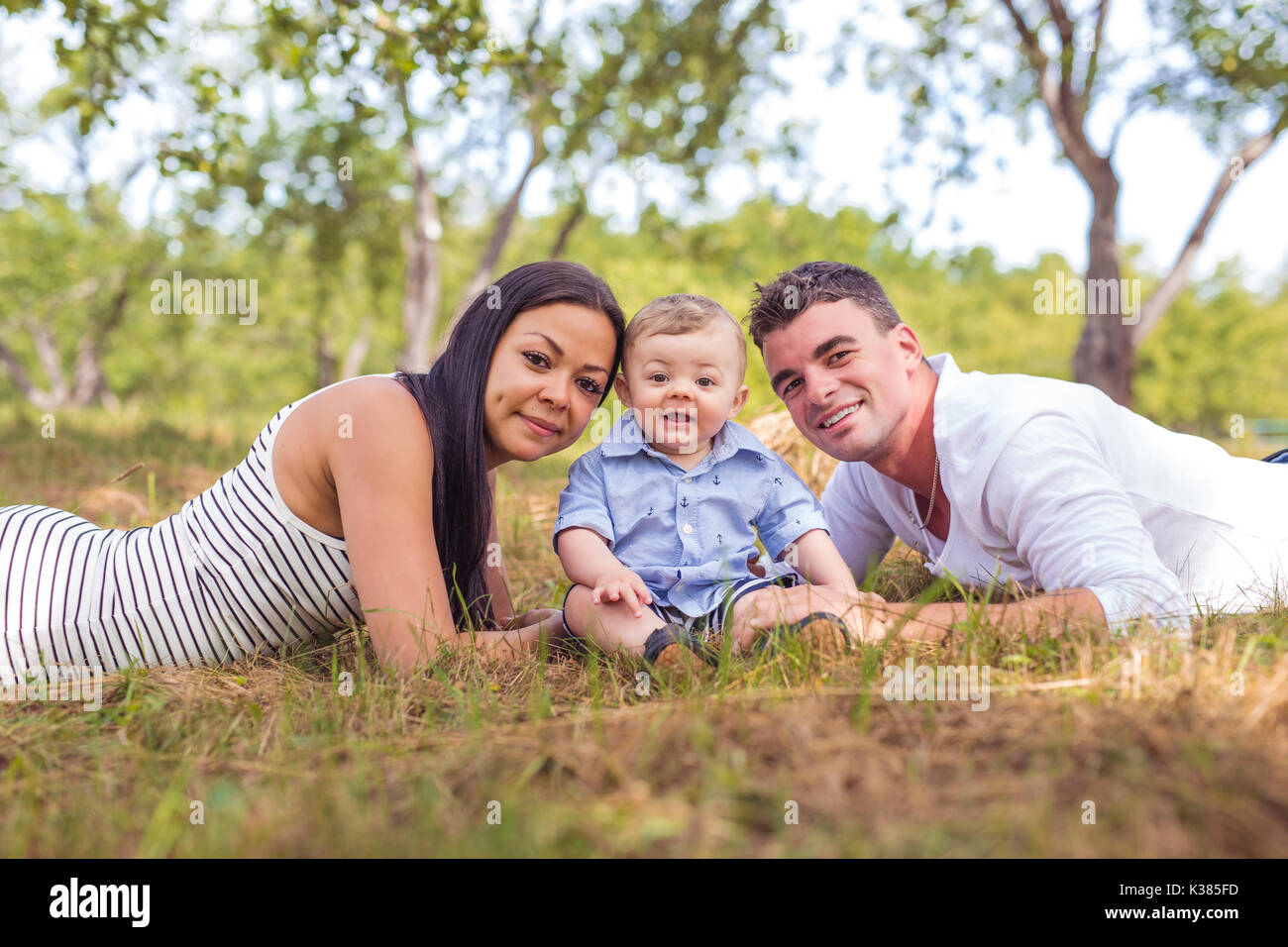 Happy Family Having fun with baby playing In The Park Stock Photo - Alamy