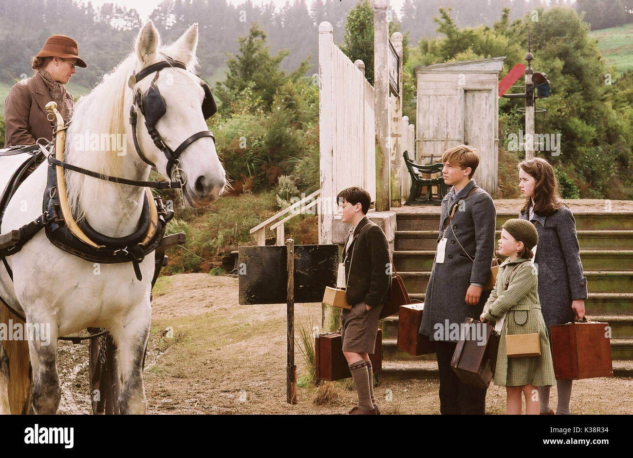 Pictured l-r: Mrs. Macready greets the children, Edmund (SKANDAR KEYNES), Peter (WILLIAM MOSELEY), Lucy (GEORGIE HENLEY), and Susan (ANNA POPPLEWELL) in a scene from THE CHRONICLES OF NARNIA: THE LION, THE WITCH AND THE WARDROBE, directed by Andrew Adamson.  Distributed by Buena Vista International. THIS MATERIAL MAY BE LAWFULLY USED IN ALL MEDIA, EXCLUDING THE INTERNET, ONLY TO PROMOTE THE RELEASE OF THE MOTION PICTU Stock Photo