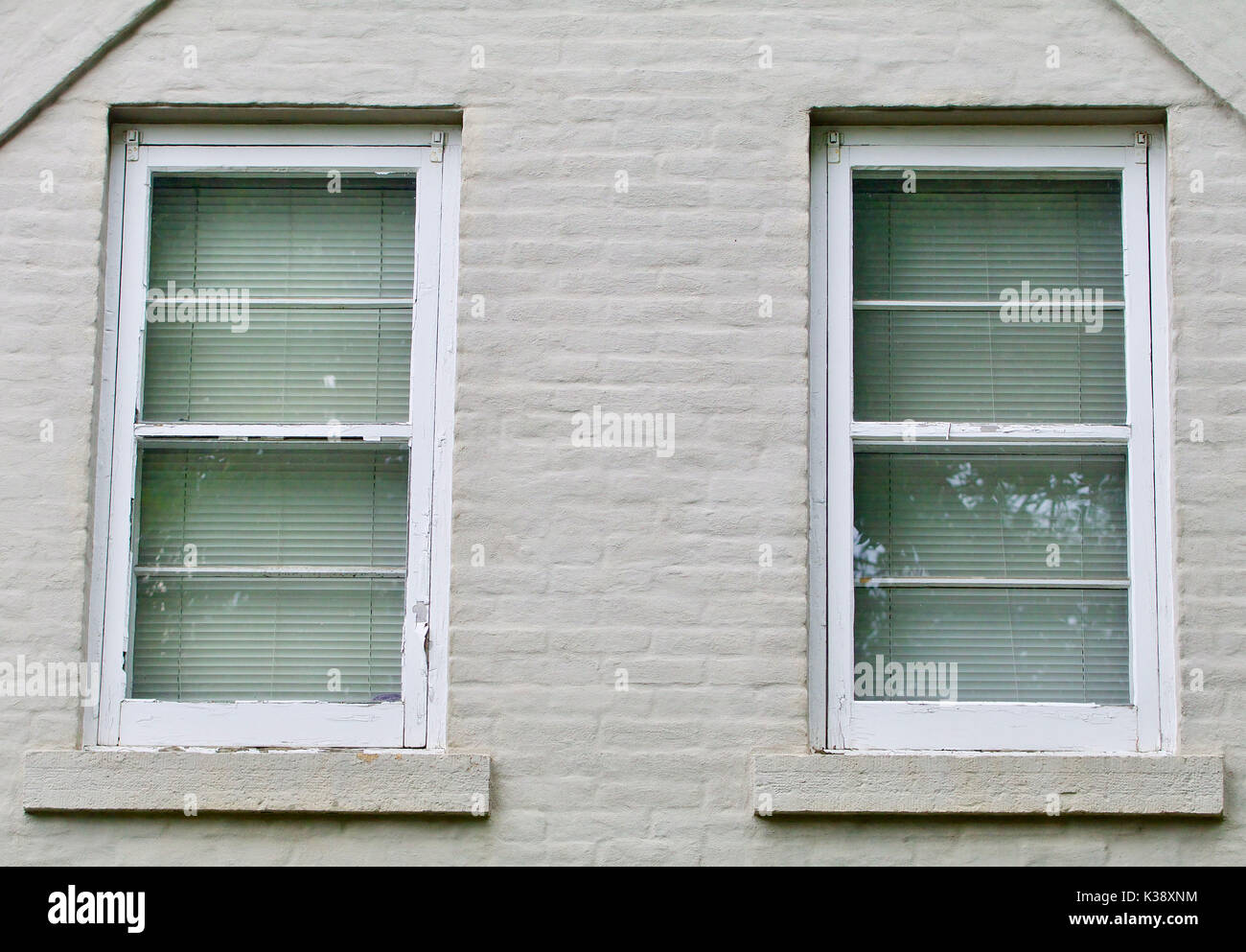 Gray brick wall with two white windows Stock Photo