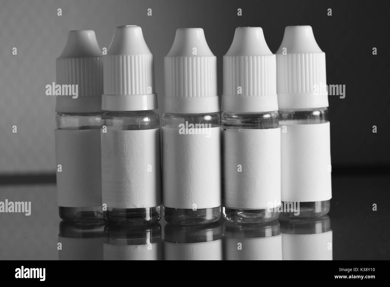 Isolated e liquid bottles for vaping devices, e cigarette, electronic cigarette, over a black background. Stock Photo