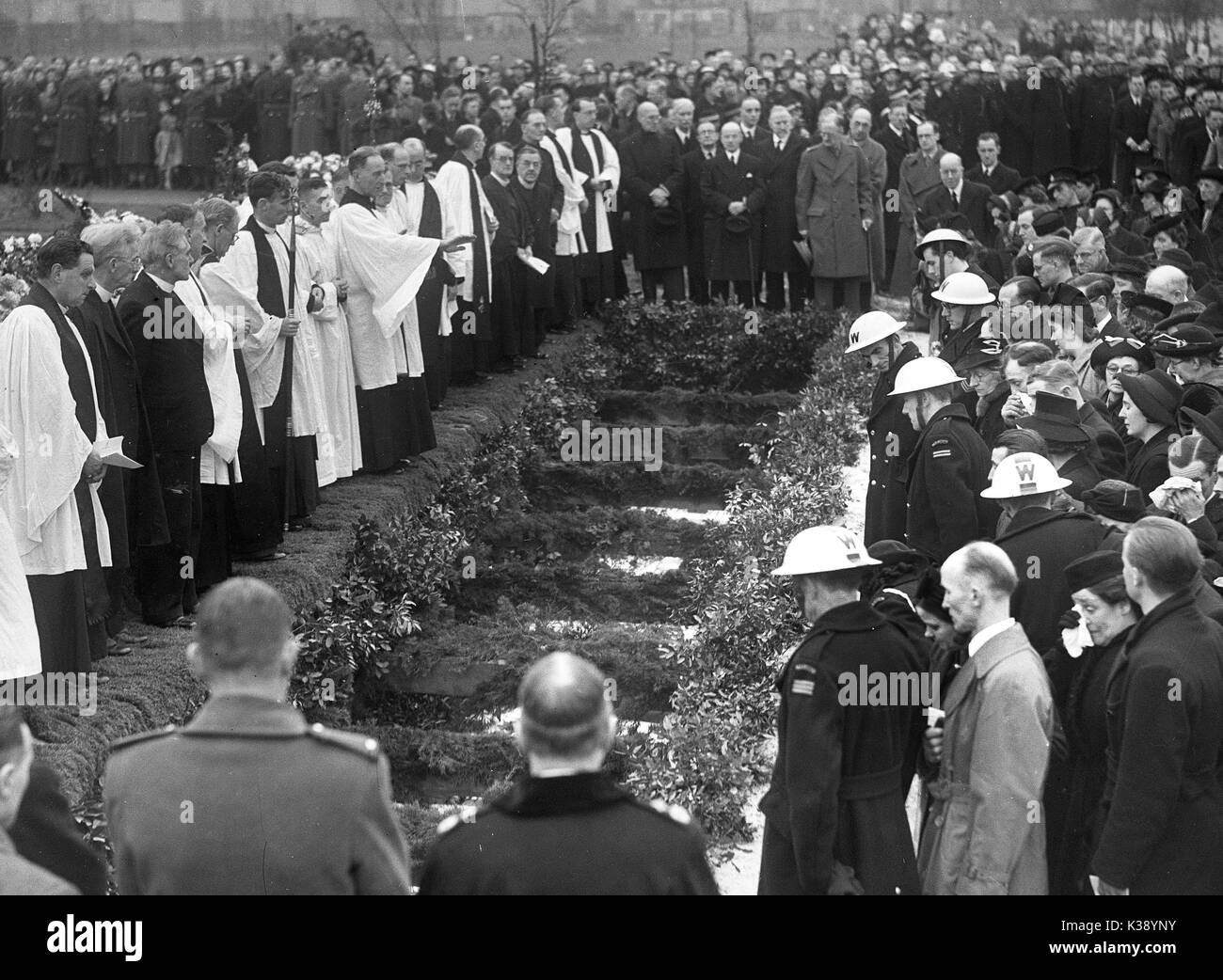 Mourners surround the mass grave as the 44 victims of a German bombing raid are buried at Hither Green Cemetery in London, World War II, 27th January 1943. Thirty-eight children and six teachers were killed when Sandhurst Road School in Catford, south London took a direct hit when a Fokker-Wolf FW 190A-4  dropped a 1,100lb bomb at 12.30pm on Wednesday, 20 January 1943. Stock Photo