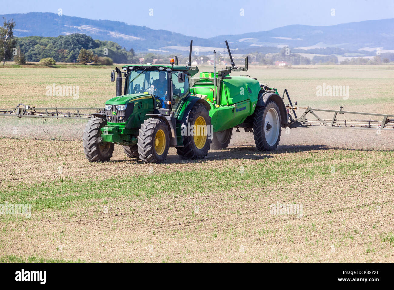 Tractor John Deere Spraying crops field, Czech Republic Farmer Stock Photo