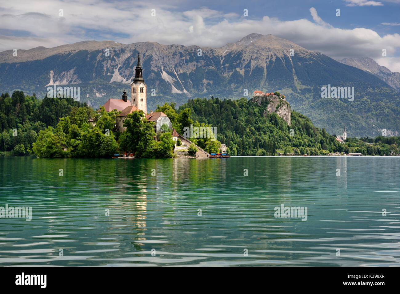 Assumption of Mary pilgrimage church Beld Island Lake Bled with Bled castle on cliff and St Martin church Sol massive of Karavanke mountains Slovenia Stock Photo