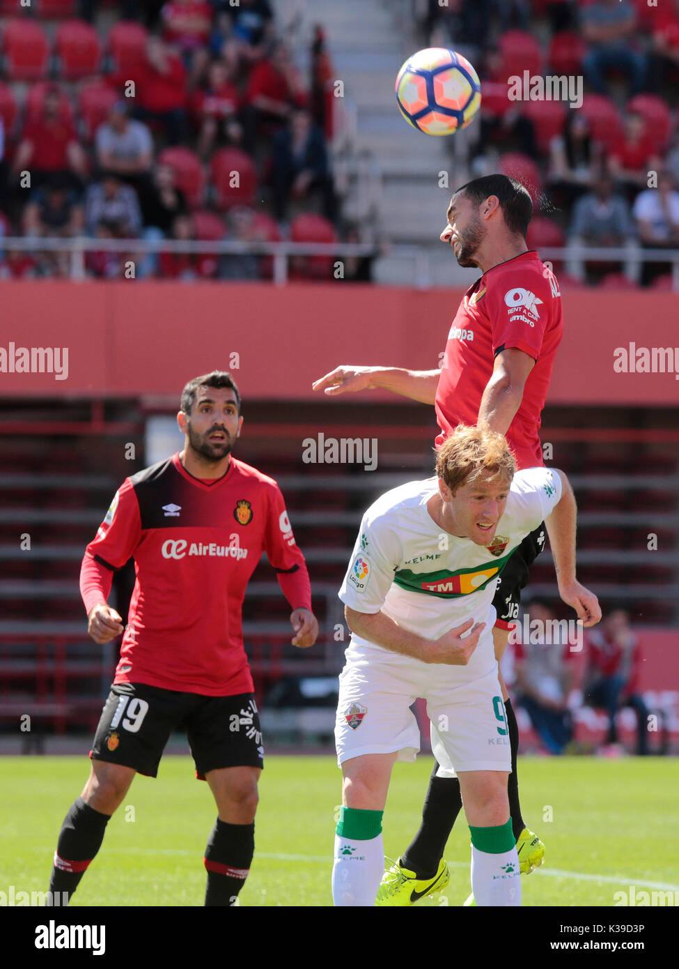 Real Mallorca player heads the ball against Sevilla atlético player during a match in Mallorca. Stock Photo