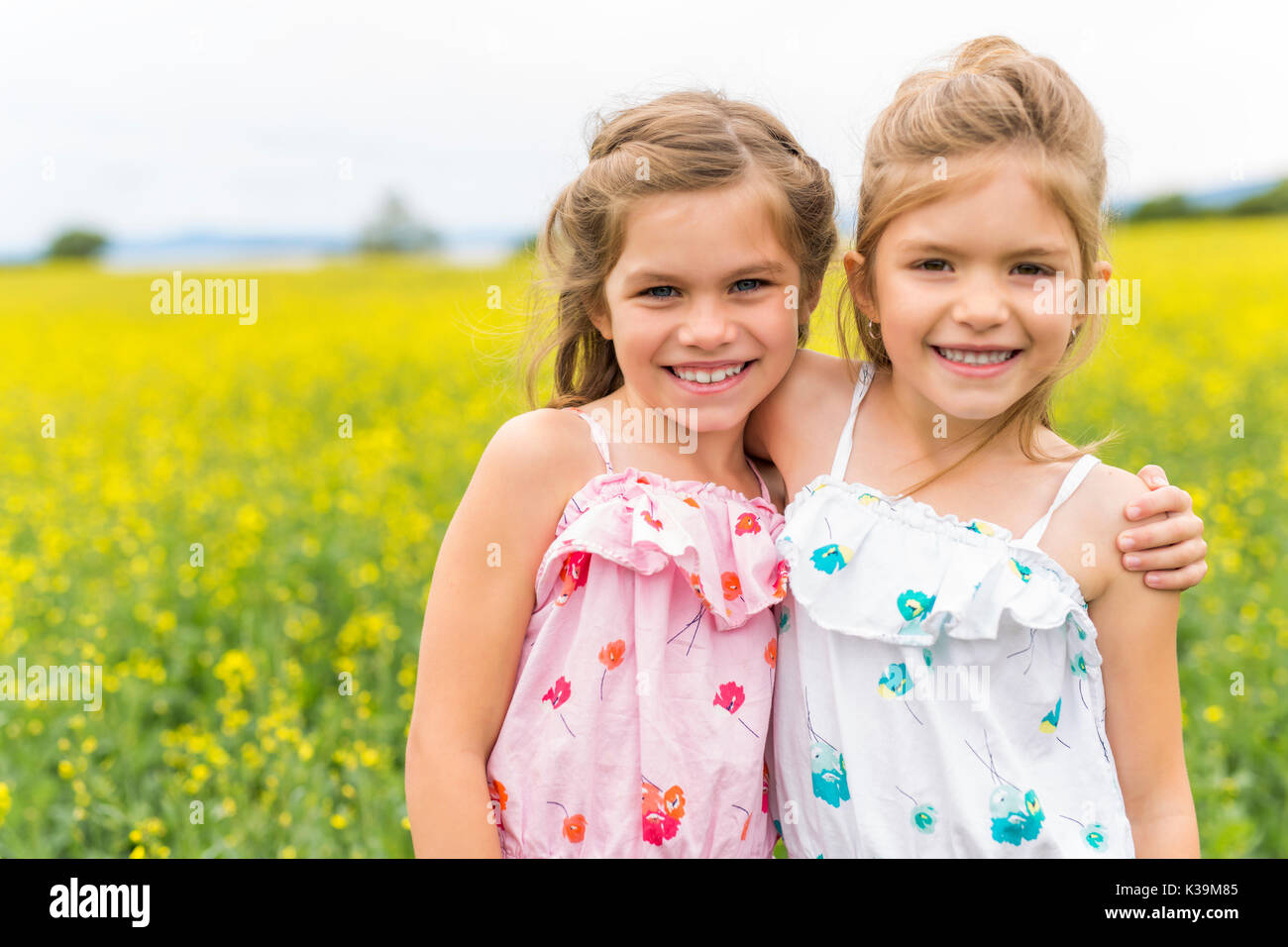 beautiful girls in a field of yellow flowers Stock Photo - Alamy