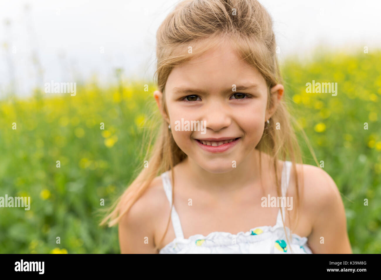 Happy girl in a field of yellow flowers Stock Photo - Alamy