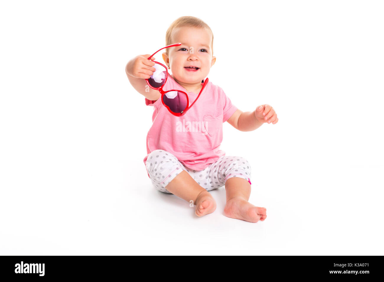 happy little baby girl in bright pink dress isolated on a white ...