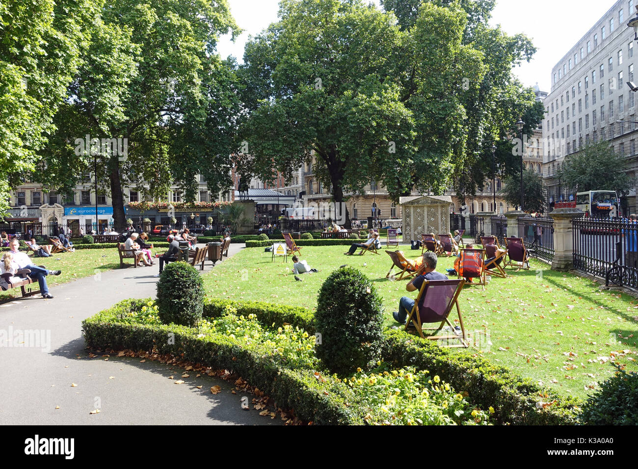 A view of people relaxing on a sunny summer day in Grosvenor Gardens in London UK Stock Photo