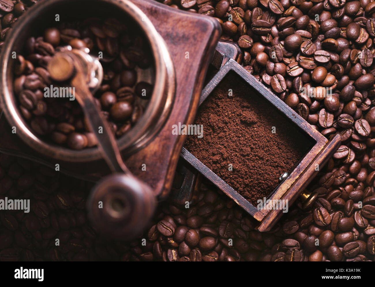 Grinding coffee from fresh roasted coffee beans. Stock Photo