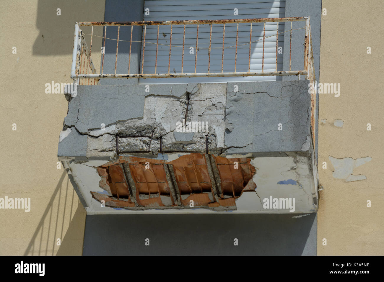 ruined balcony that is about to collapse with visible construction steel and bricks Stock Photo