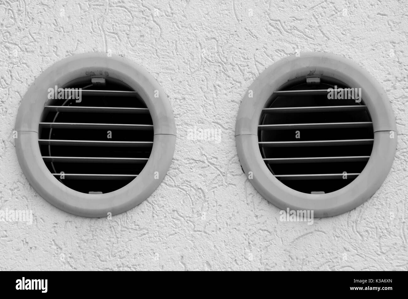 hole in the wall with a grid to make the air flow from a room of a building to the outside environment Stock Photo