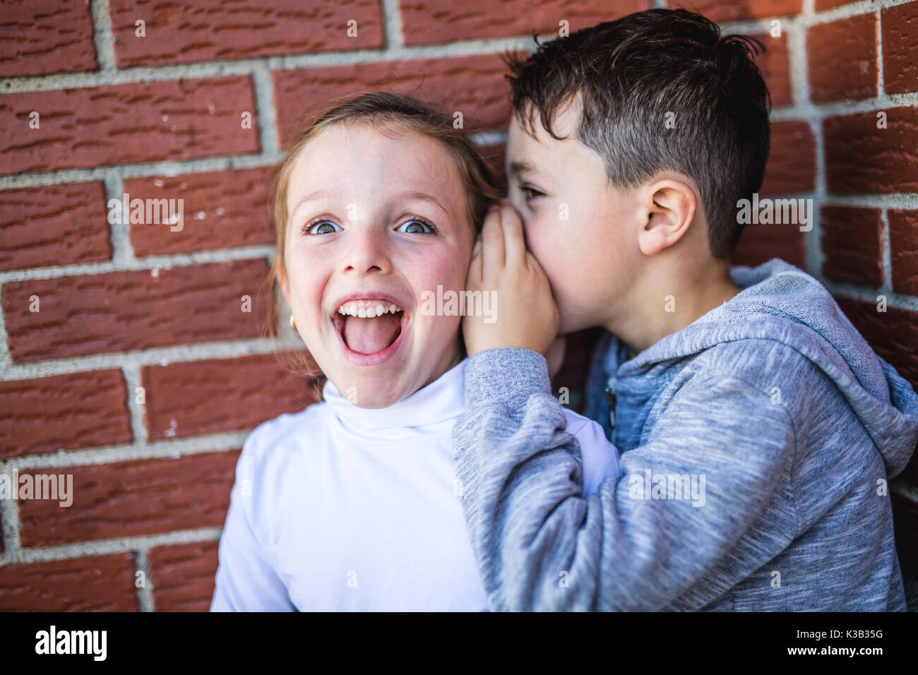 Little boy and girl whispers a secret. Stock Photo